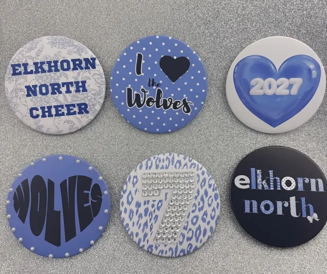 Six handmade fabric button pins for Elkhorn North Cheer in blue, white and black
